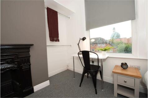 Neat, well-lit bedroom with a study corner by t...