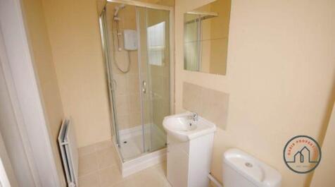 Bright, modern bathroom with a corner glass sho...