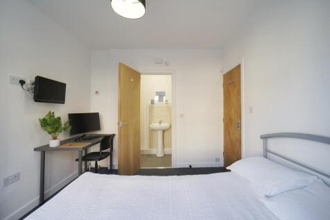 Bright, modern double bedroom with a neatly mad...