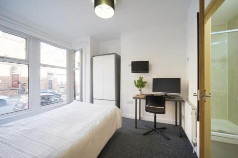 Bright, modern bedroom with large street-facing...