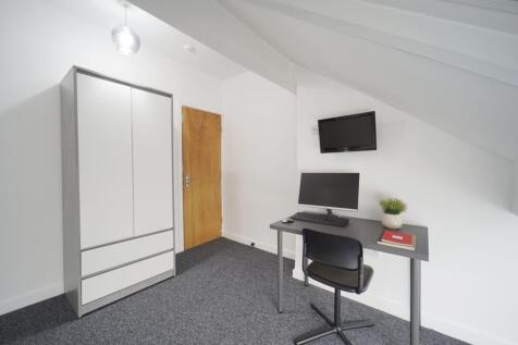 Brightly painted attic single bedroom with slop...