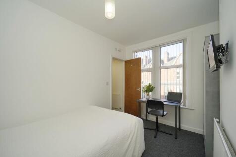 Bright, simply furnished bedroom with a comfort...