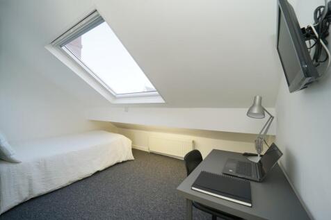 Bright attic bedroom with a sloped ceiling and ...