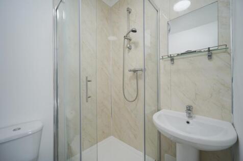 Bright, modern bathroom with a glass-enclosed s...