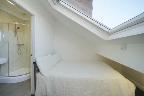 Bright attic bedroom with a skylight providing ...