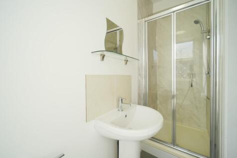 Bright, modern bathroom with a pedestal sink, m...