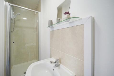 Bright, modern bathroom with a clear glass show...