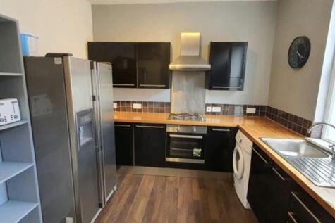 Modern galley-style kitchen with dark cabinetry...