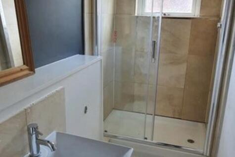 Bright, modern bathroom with a glass-enclosed s...
