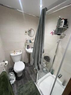 Neat, modern bathroom with a corner shower cubi...