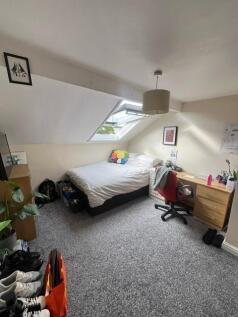Bright attic bedroom with a sloped ceiling and ...