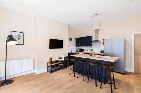 Bright open-plan kitchen with a long island bre...