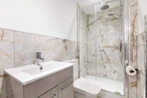Bright, modern bathroom with marble-effect tili...