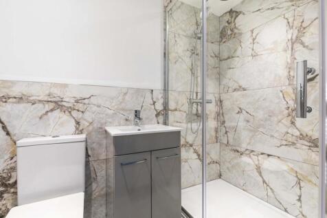 Modern bathroom with a glass-enclosed shower, s...