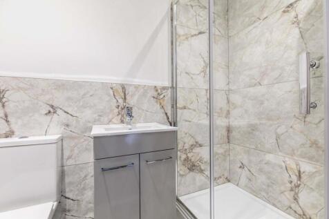 Modern bathroom with stone-effect wall tiles, g...