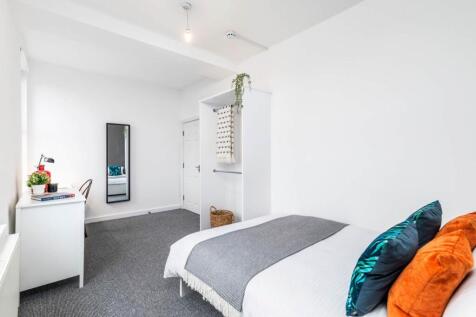 Bright, simply furnished bedroom with a double ...