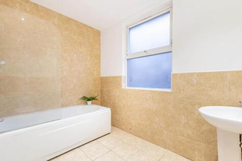 Bright, modern bathroom with a white bath, pede...