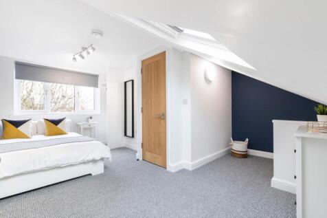 Bright, modern attic bedroom with a comfortable...