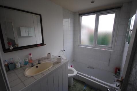 Bright bathroom with a large frosted window, ti...