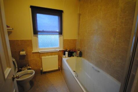 Well-appointed bathroom with a tiled bath and m...
