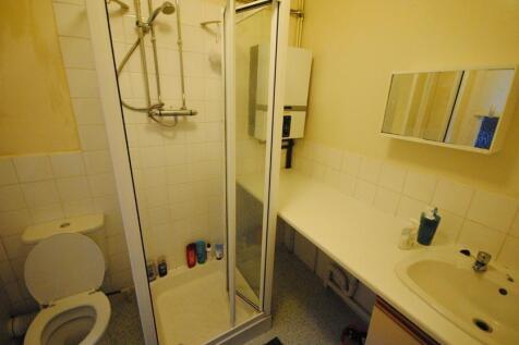 Compact bathroom with a walk-in shower, vanity ...