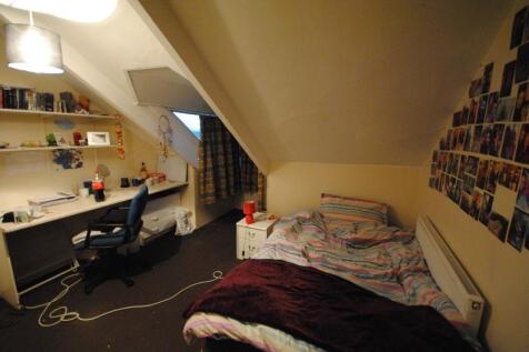 Cozy attic-style bedroom with a comfortable sin...