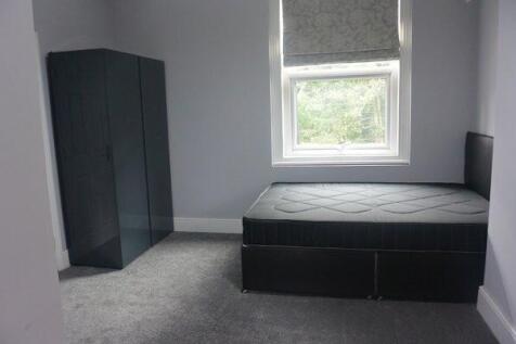 Bright, simply furnished bedroom with a large w...