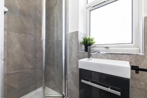 Bright, modern bathroom with a glass corner sho...