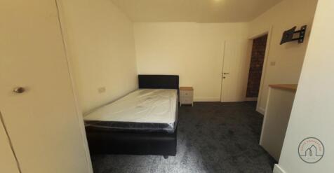 Bright, simply furnished bedroom with a double ...