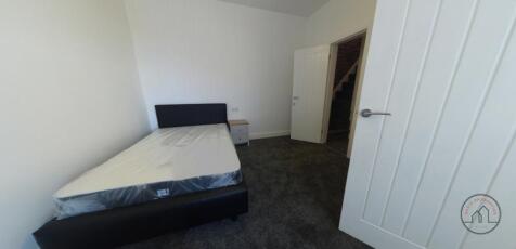 Bright, simply furnished bedroom with a comfort...