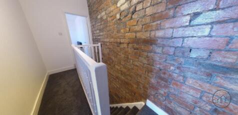 Bright stairwell with an exposed brick feature ...