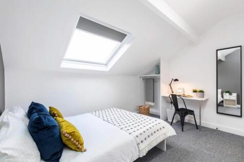 Bright, contemporary attic bedroom with a comfy...