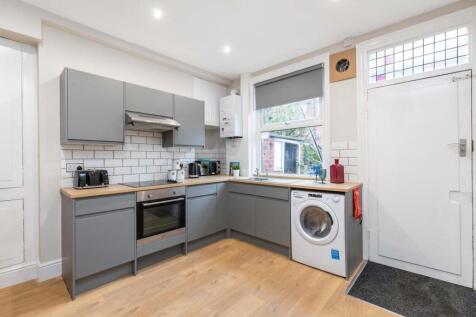 Bright, modern kitchen with grey cabinetry, woo...