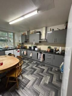 Bright, modern kitchen with grey fitted cabinet...
