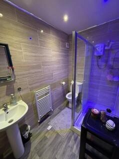 Modern tiled bathroom with a walk-in shower, pe...