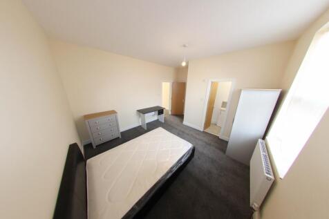 Bright, simply furnished bedroom with a double ...
