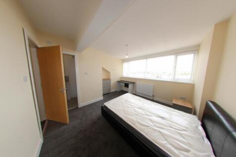 Bright, simply furnished bedroom with a double ...