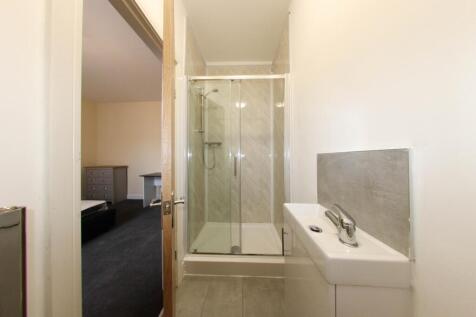 Bright modern bathroom with a glass-enclosed sh...