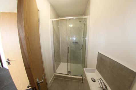 Bright, modern bathroom with a glass-enclosed s...