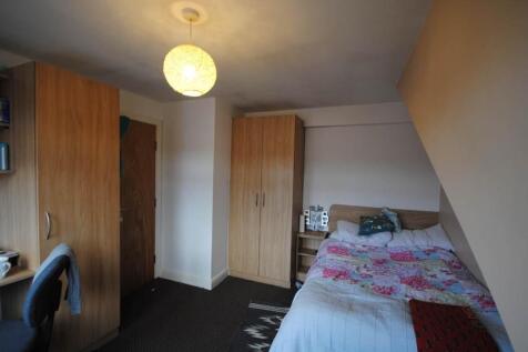 Bright, neatly furnished bedroom with a double ...