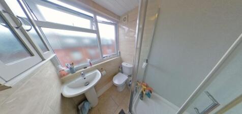 Bright, tiled bathroom with a shower enclosure,...