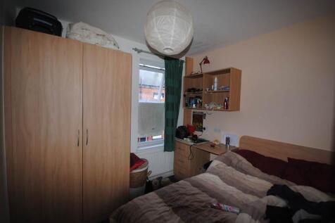 Cozy furnished bedroom with a wardrobe, desk, s...