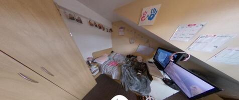 Compact attic-style bedroom with sloped ceiling...