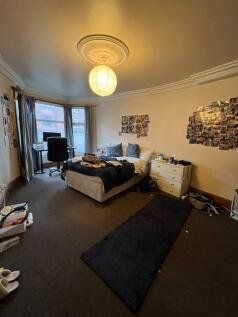 Spacious double bedroom with a comfortable bed,...