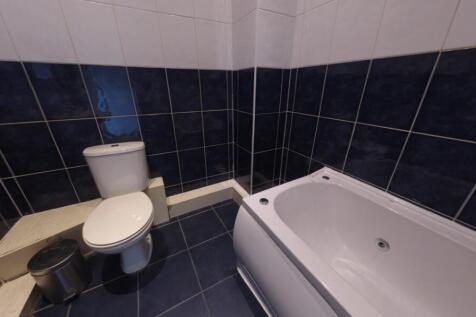 Modern tiled bathroom with a full-size bathtub,...