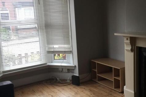 Bright living room with a large bay window lett...