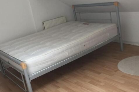 Bright, simply furnished bedroom with a metal d...