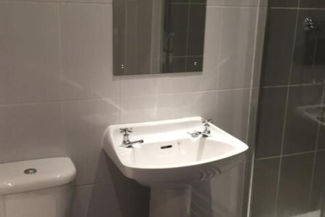 Modern tiled bathroom with a pedestal sink, WC ...