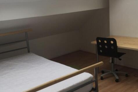 Neat attic-style bedroom with a simple metal-fr...