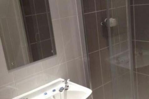 Modern tiled bathroom with a wall-mounted mirro...